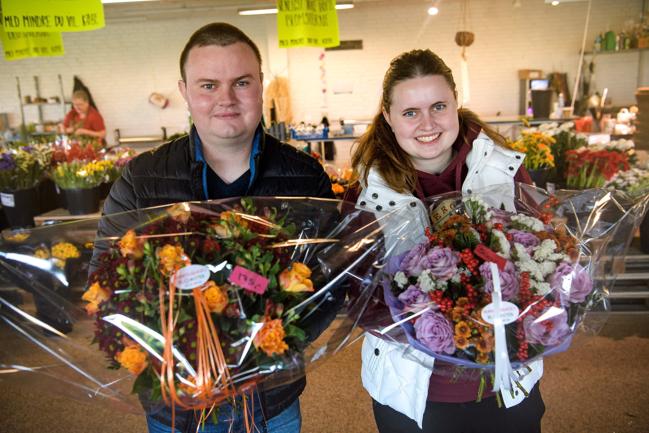 De to nye indehavere af Markedsgades Blomster, 
                                Søren og Mette Kaptain med to store buketter blomster, 
                                inde i blomsterbutikken